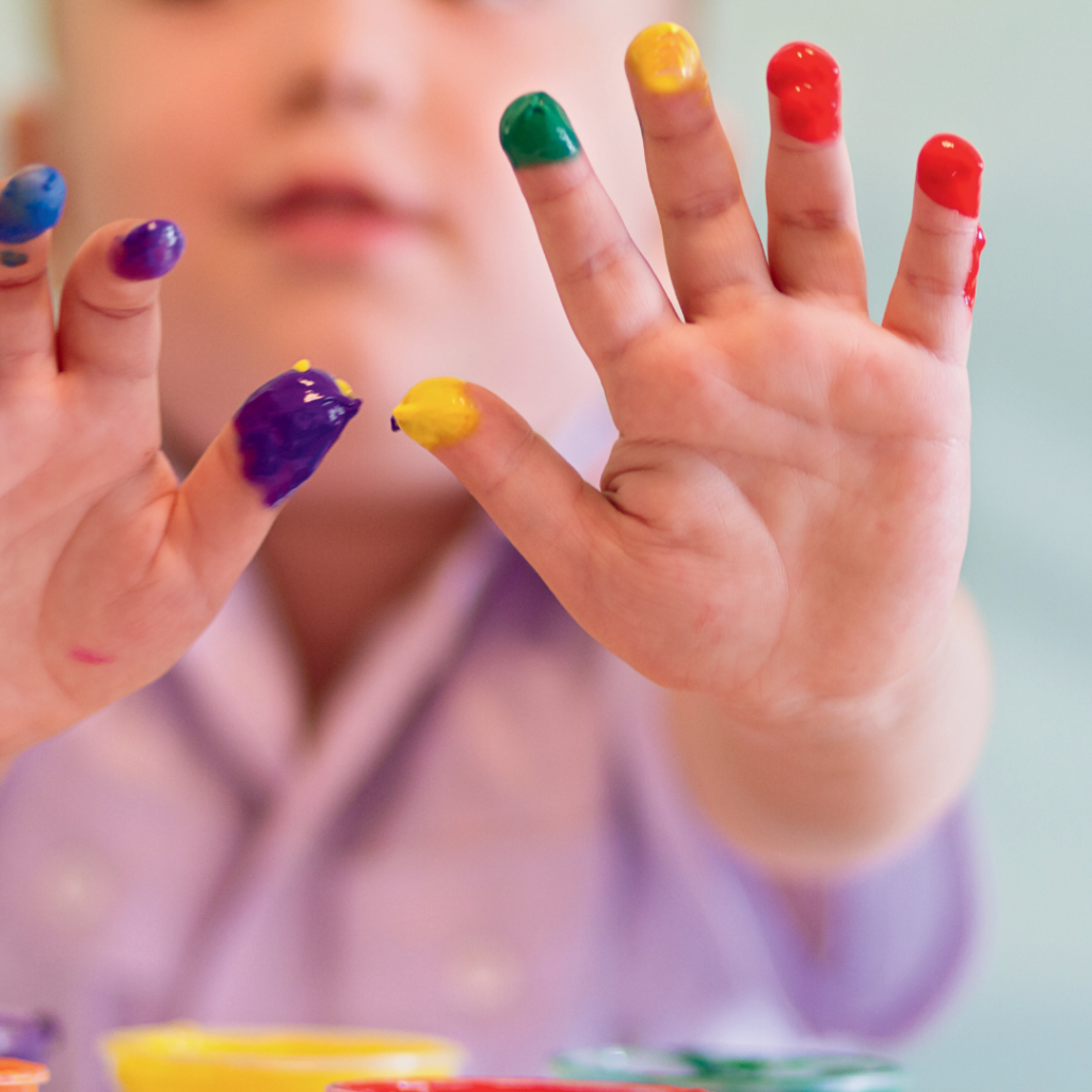 Small child with paint on their finger tips