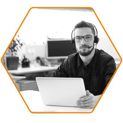 Man with headset sat at laptop with image framed in orange hexagon
